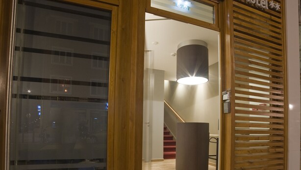 The exterior of Le Citadel Hotel with a wooden facade, large glass doors, and a staircase leading to the entrance. - Citadel Hotel (Calais)
