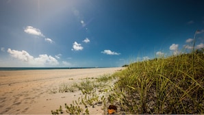 A beach with sand and sparse vegetation. - Sun Dek Beach House (Boynton Beach)