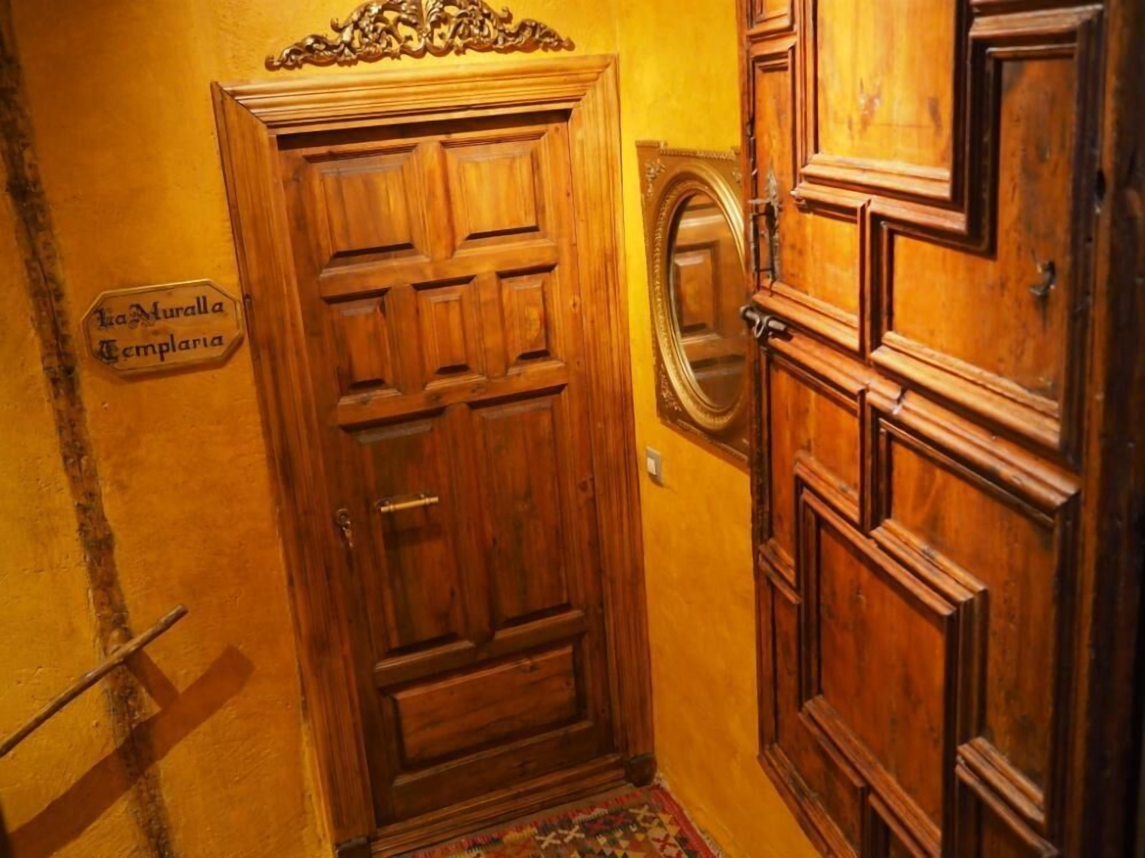 Une porte en bois portant une inscription : « La Muralla Templaria ».