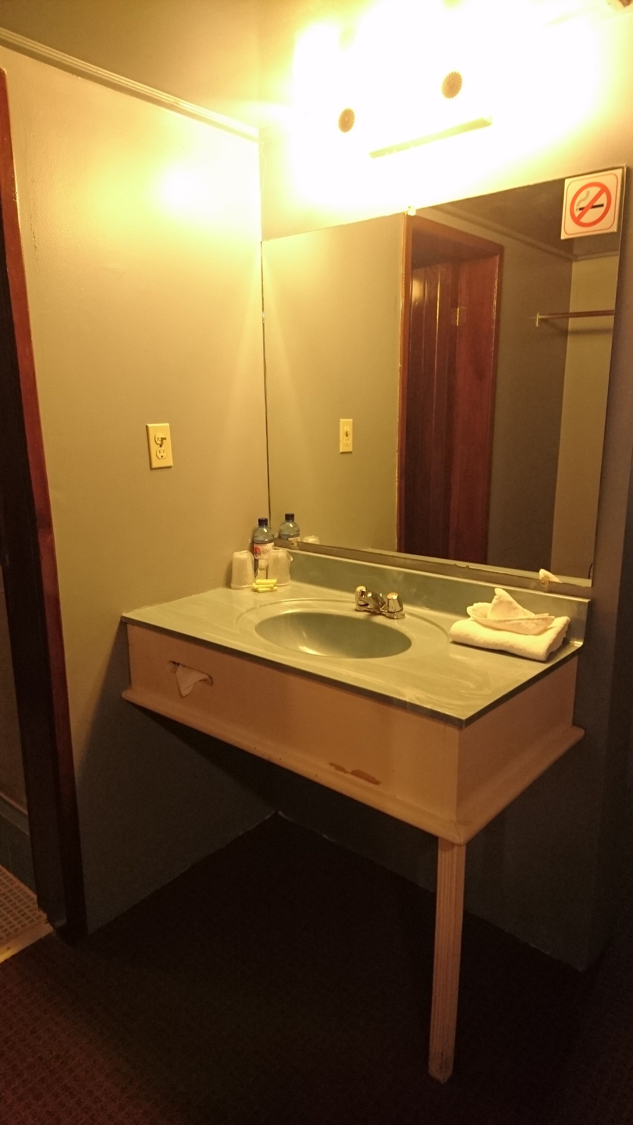 Ein Badezimmer mit Waschbecken, Spiegel und Handtuchhalter.
