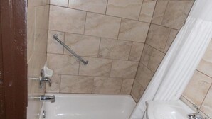 A bathroom with a bathtub, a toilet, and a handrail. - Maples Motel (Orillia)