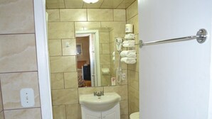 A bathroom with a toilet, sink, and towel rack. - Maples Motel (Orillia)