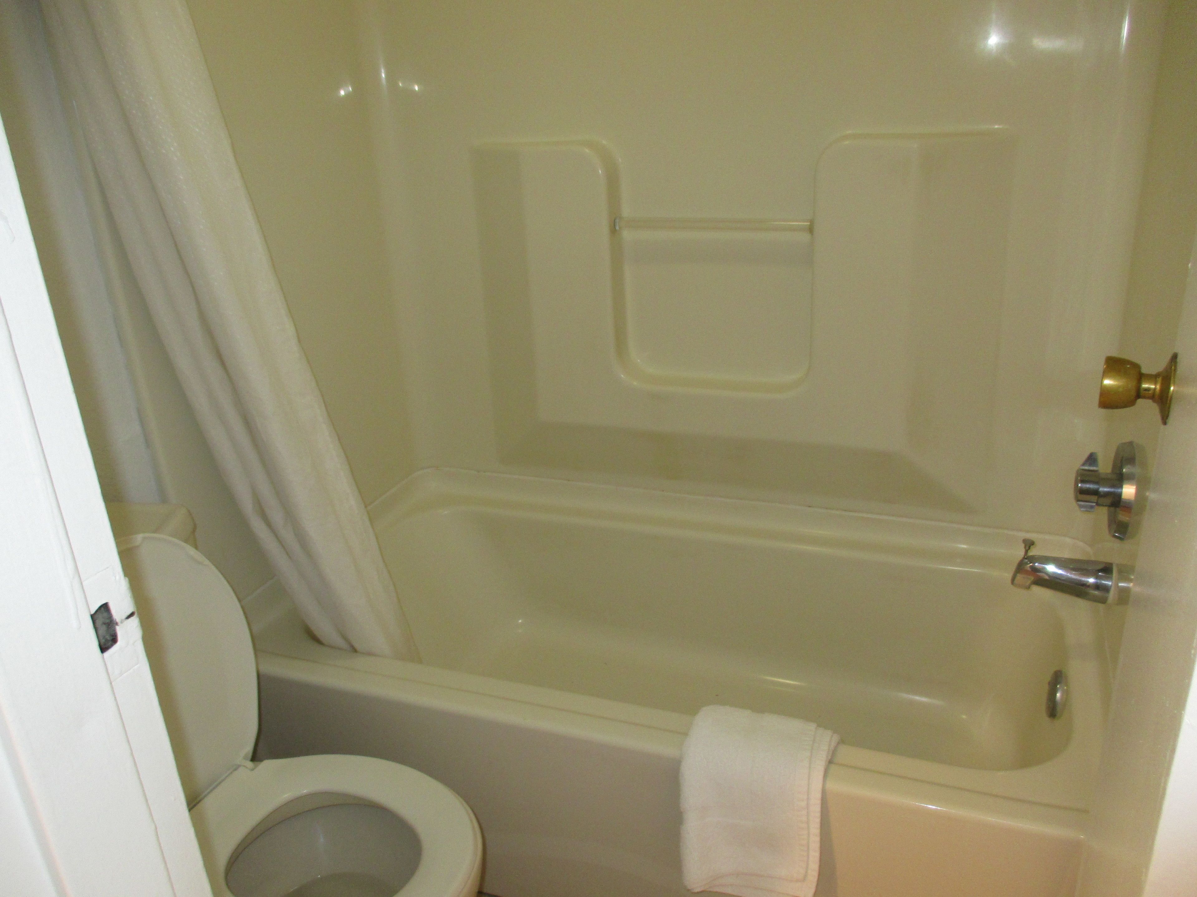 Une salle de bain avec une baignoire, des toilettes et un rideau de douche.