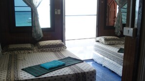 A room with two beds, one larger and one smaller, both with patterned bedding.