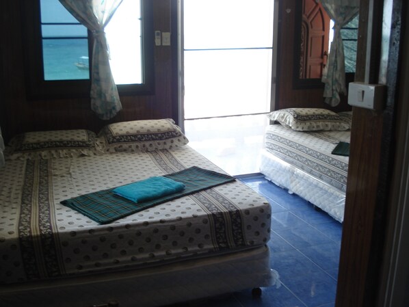 A room with two beds, one larger and one smaller, both with patterned bedding.