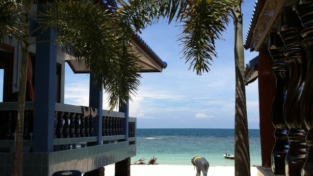 A beachside building with a balcony overlooking the ocean.