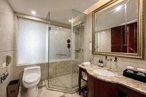A modern bathroom with a glass-enclosed shower, a white toilet, and a vanity with a large mirror. - Phoenix International Hotel (Dazhou)