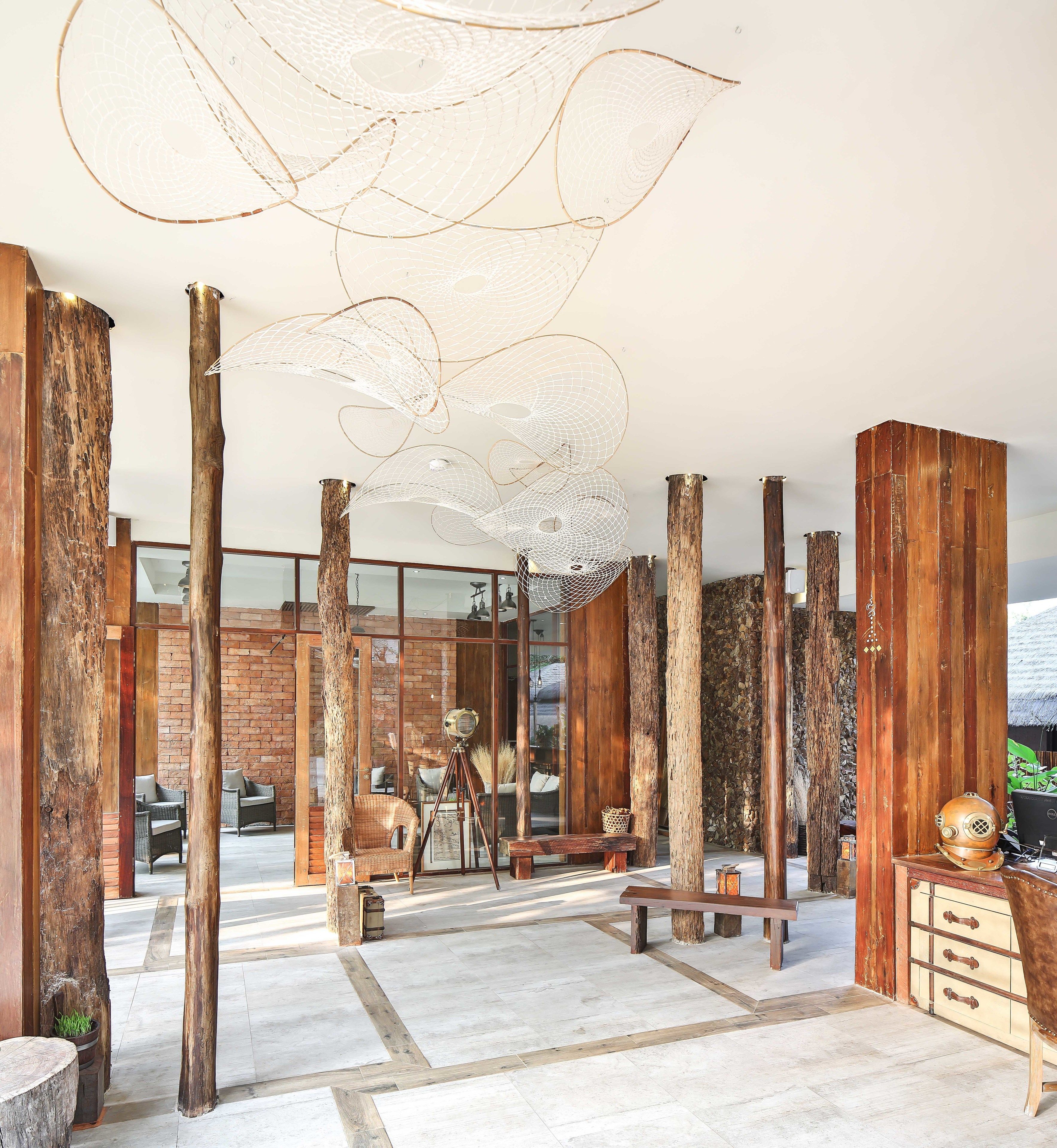 A modern interior with exposed wooden beams, a glass wall, and a unique ceiling light fixture.