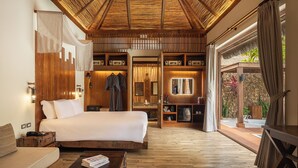 Un dormitorio espacioso con una cama grande, techo de madera y vista a una piscina.