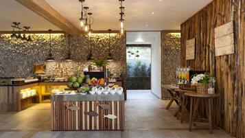 A modern kitchen with a central island, stone wall, wooden accents, and pendant lighting.