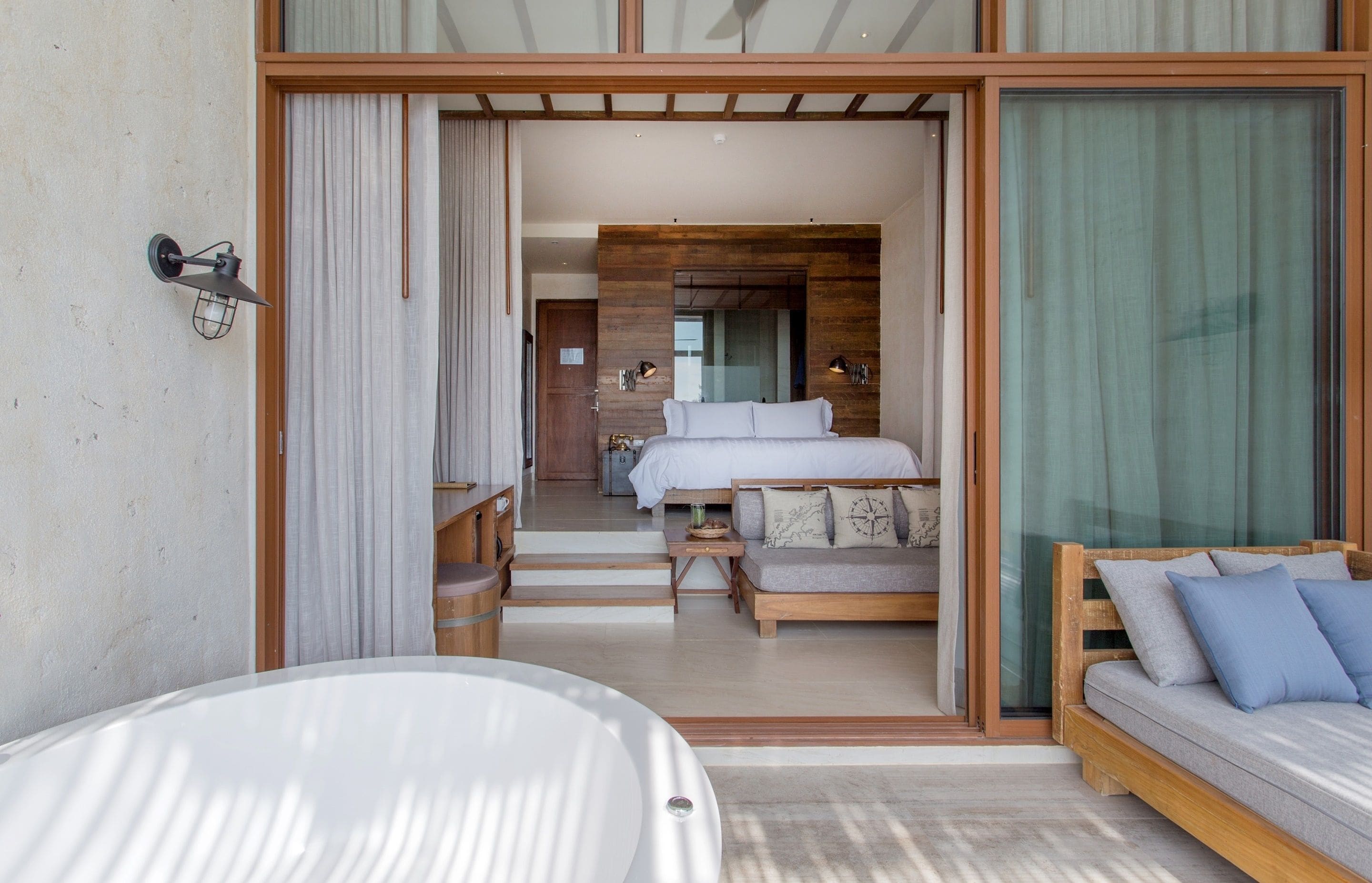 Una habitación de hotel moderna con una cama grande, un sofá y una bañera.