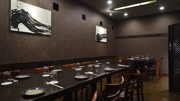 A conference room with long tables, chairs, and artwork on the walls.