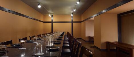 A conference room with a long table, chairs, and a bench.