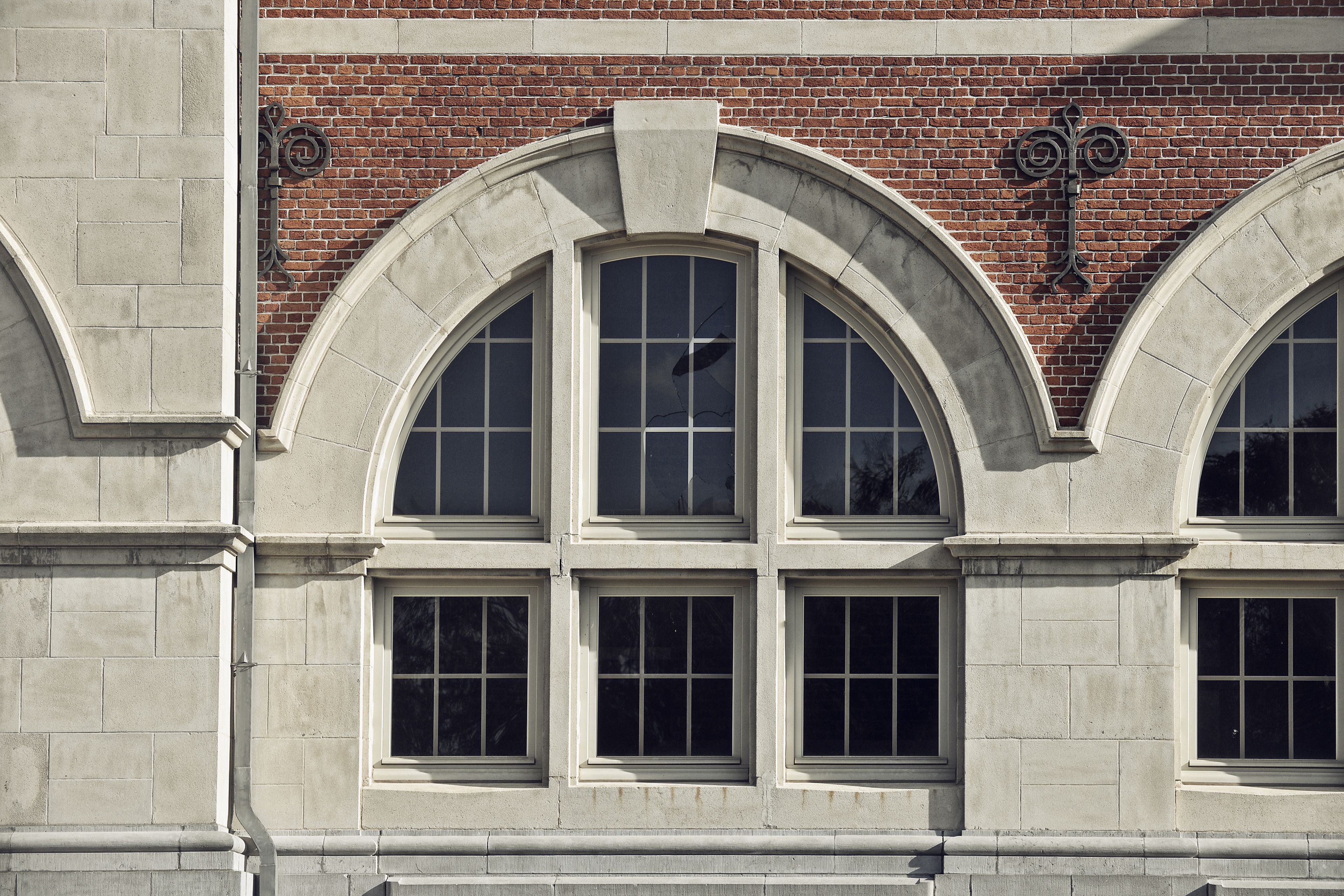 A building facade with arched windows and a brick wall.