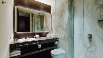 Une salle de bain moderne avec un meuble-lavabo en marbre, une cabine de douche en verre et des toilettes.