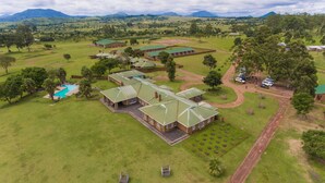 An aerial view of a large estate with multiple buildings, a swimming pool, and well-maintained lawns. - Game Haven Lodge (Chigumula)