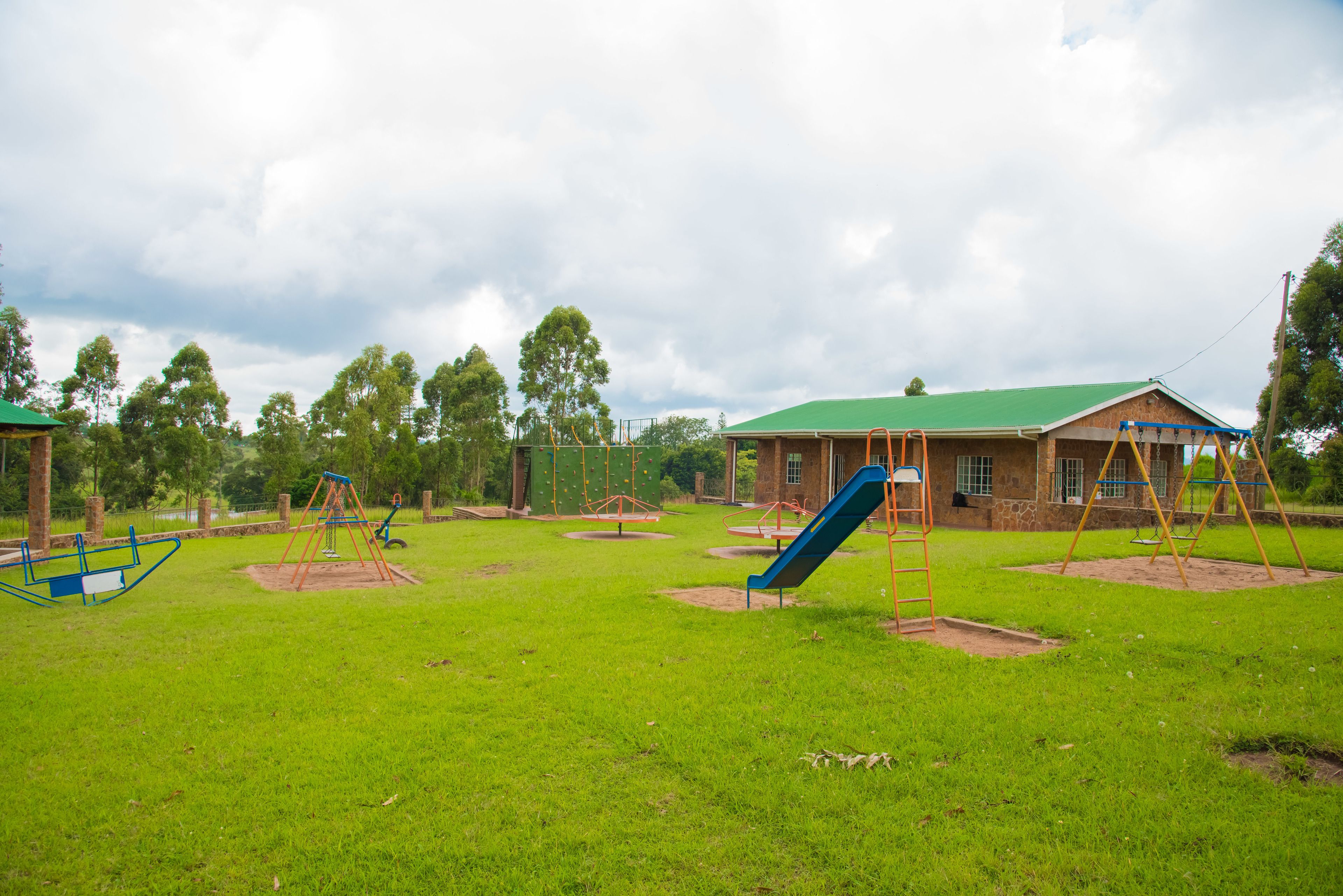 A playground with swings, a slide, and a climbing structure.