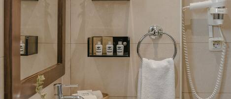 A bathroom with a sink, mirror, towel rack, and a hairdryer.