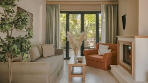 Un salon comprenant un canapé, une table basse, une cheminée et une grande fenêtre avec des rideaux.