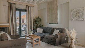 Un salon moderne avec un canapé, une table en bois et un vase décoré de plumes d’herbe des pampas.