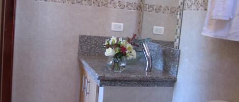 A bathroom with a toilet, sink, and mirror.