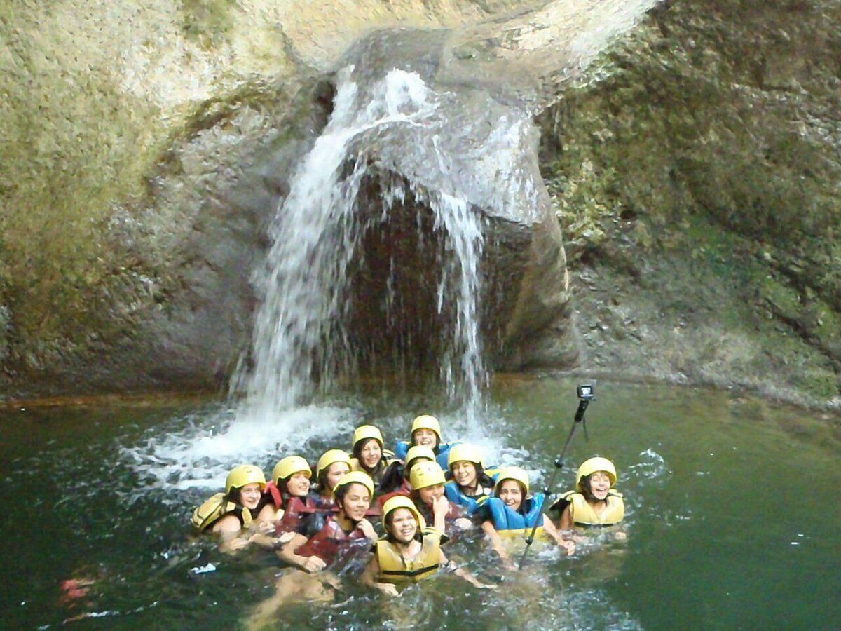 Un grupo de personas en un entorno natural con una cascada.