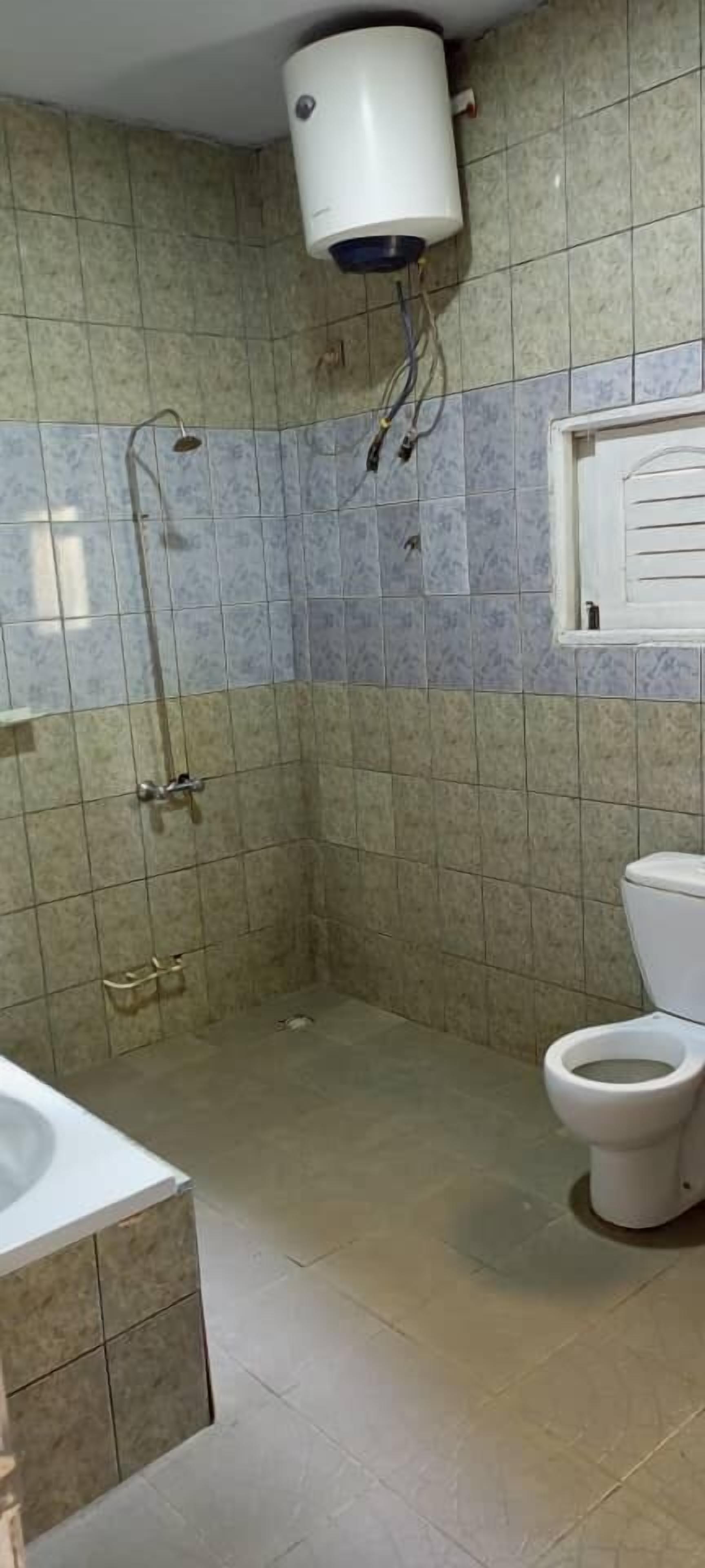 A bathroom with a shower, toilet, and sink.