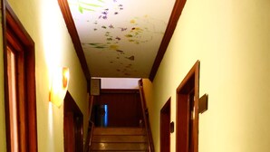 Ein Flur mit Holztüren, Fliesenboden und einer Treppe zu einer oberen Etage.