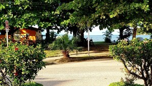 A paved pathway leading to a covered area with a view of the sea. - HOTELARE Hotel Brunello (Paraty)