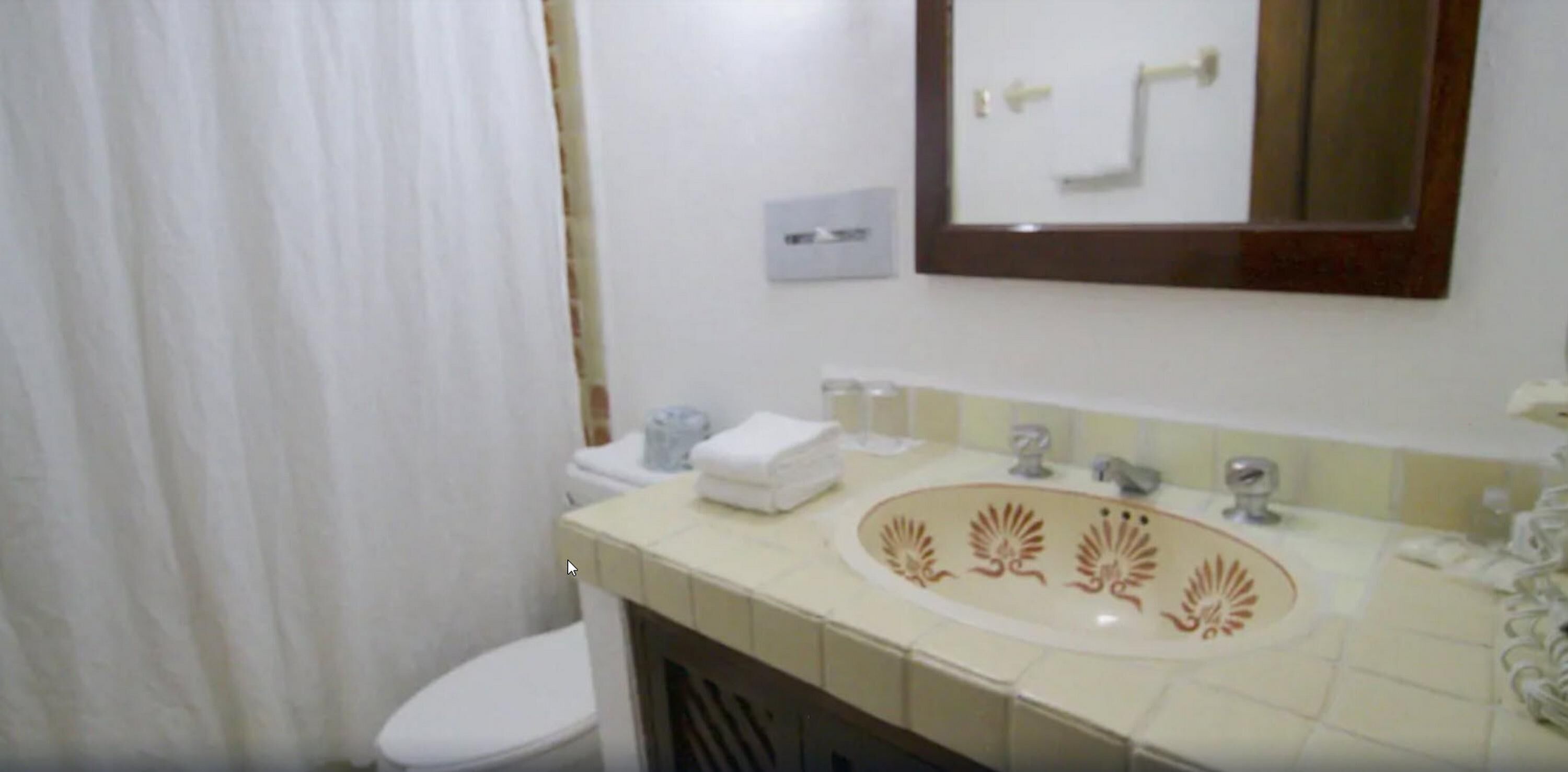 Un baño con inodoro, lavabo y espejo.
