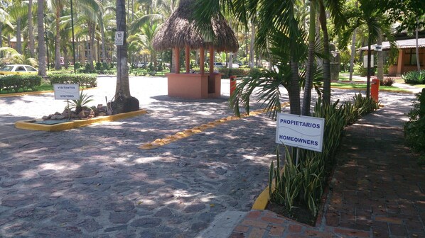 Un espacio pavimentado con un cartel para visitantes y otro para propietarios.
