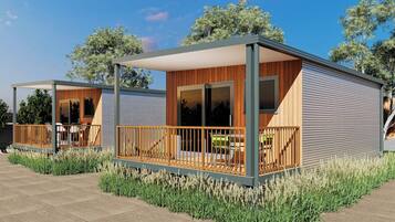 A modern, two-story building with a covered patio area, large windows, and a wooden deck.