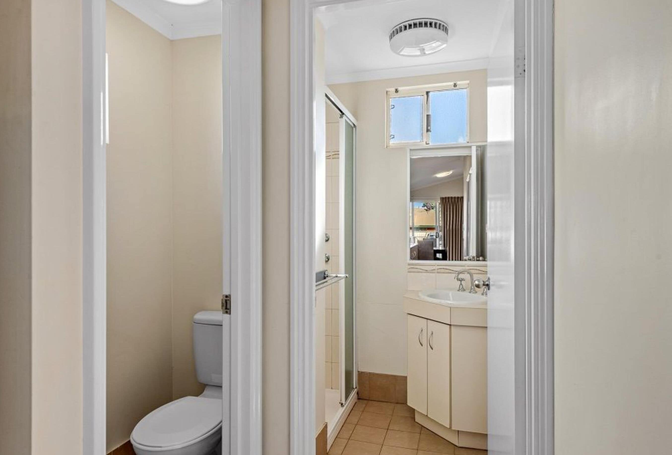 Un baño pequeño con inodoro, ducha y lavamanos.