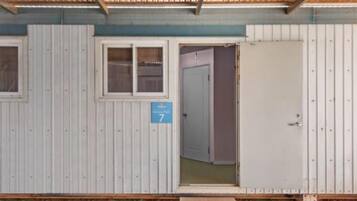 Una estructura de una sola habitación con una puerta y una ventana, con un cartel que indica el número 7.