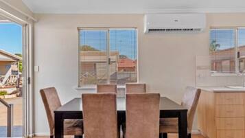 A dining area with a table and chairs, a kitchen with cabinets, and a sliding glass door leading to an outdoor area.