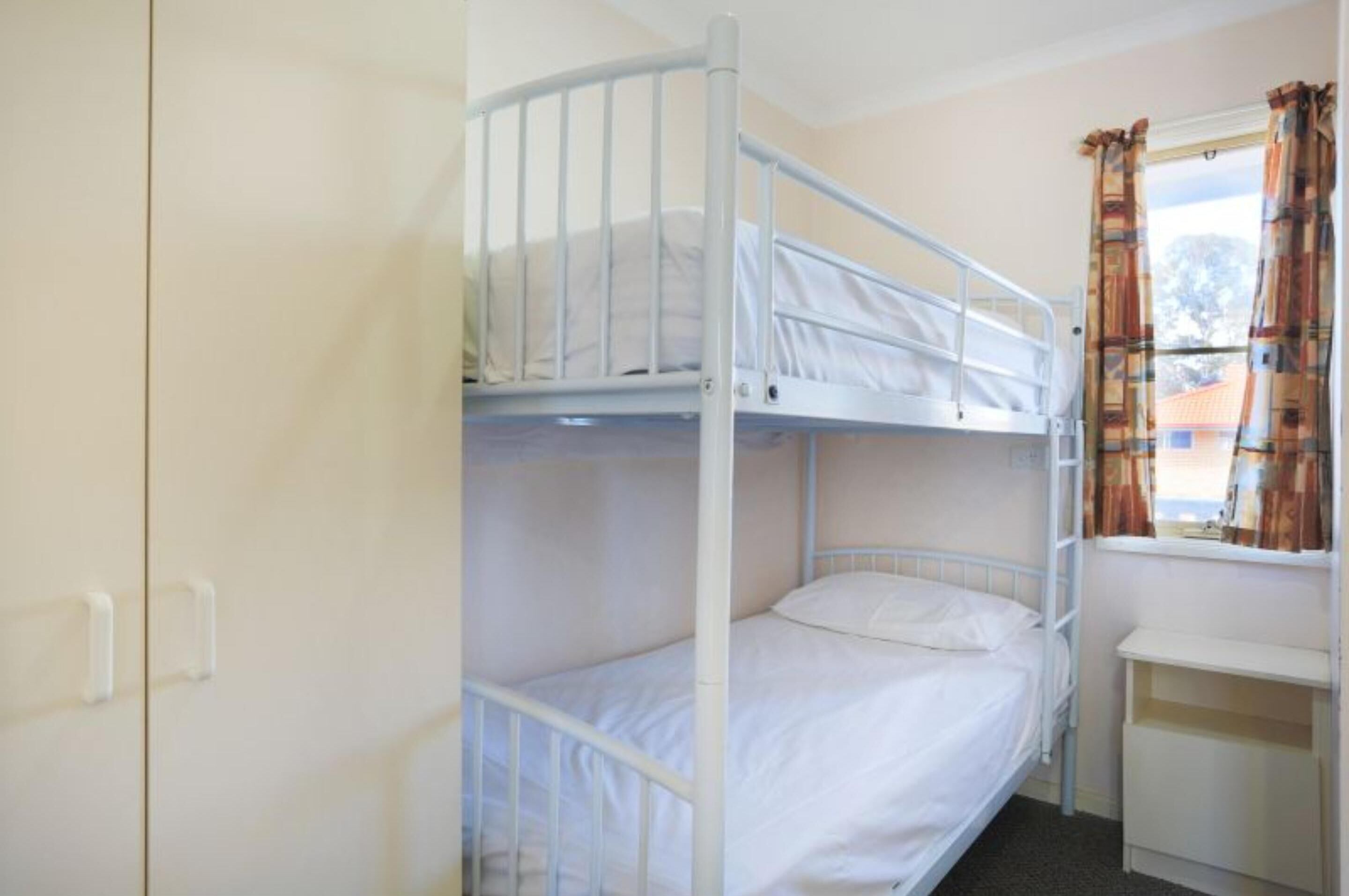 A bunk bed room with a window and curtains.