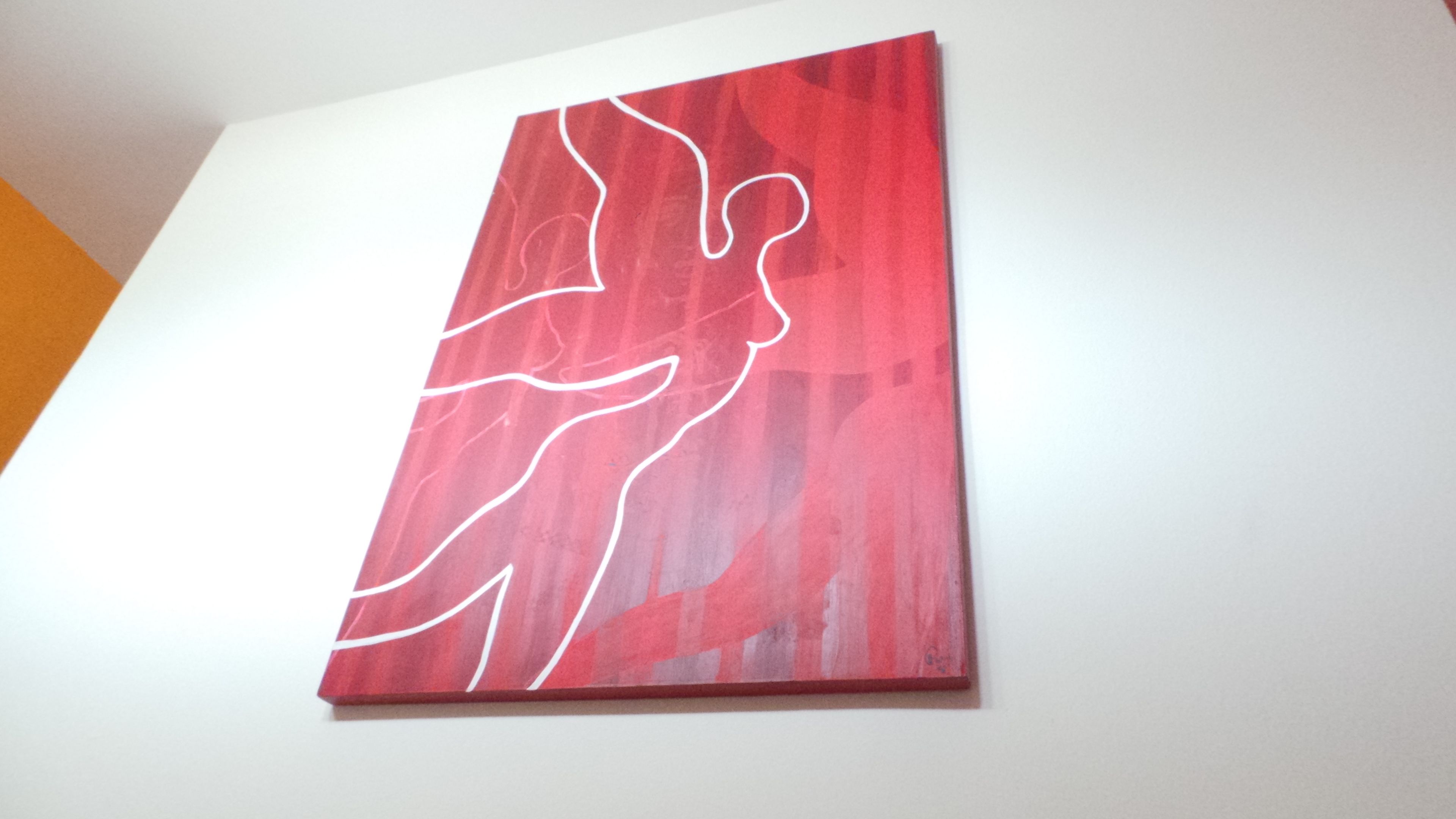Ein rotes, abstraktes Gemälde an einer weißen Wand.