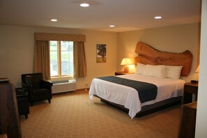 A hotel room with a bed, a chair, a desk, a lamp, and a window with curtains. - Hotel Floyd (Floyd)