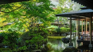 A serene garden with a pond, rocks, and a wooden pavilion. - KINUGAWA GRAND HOTEL YUME no TOKI (Nikko)