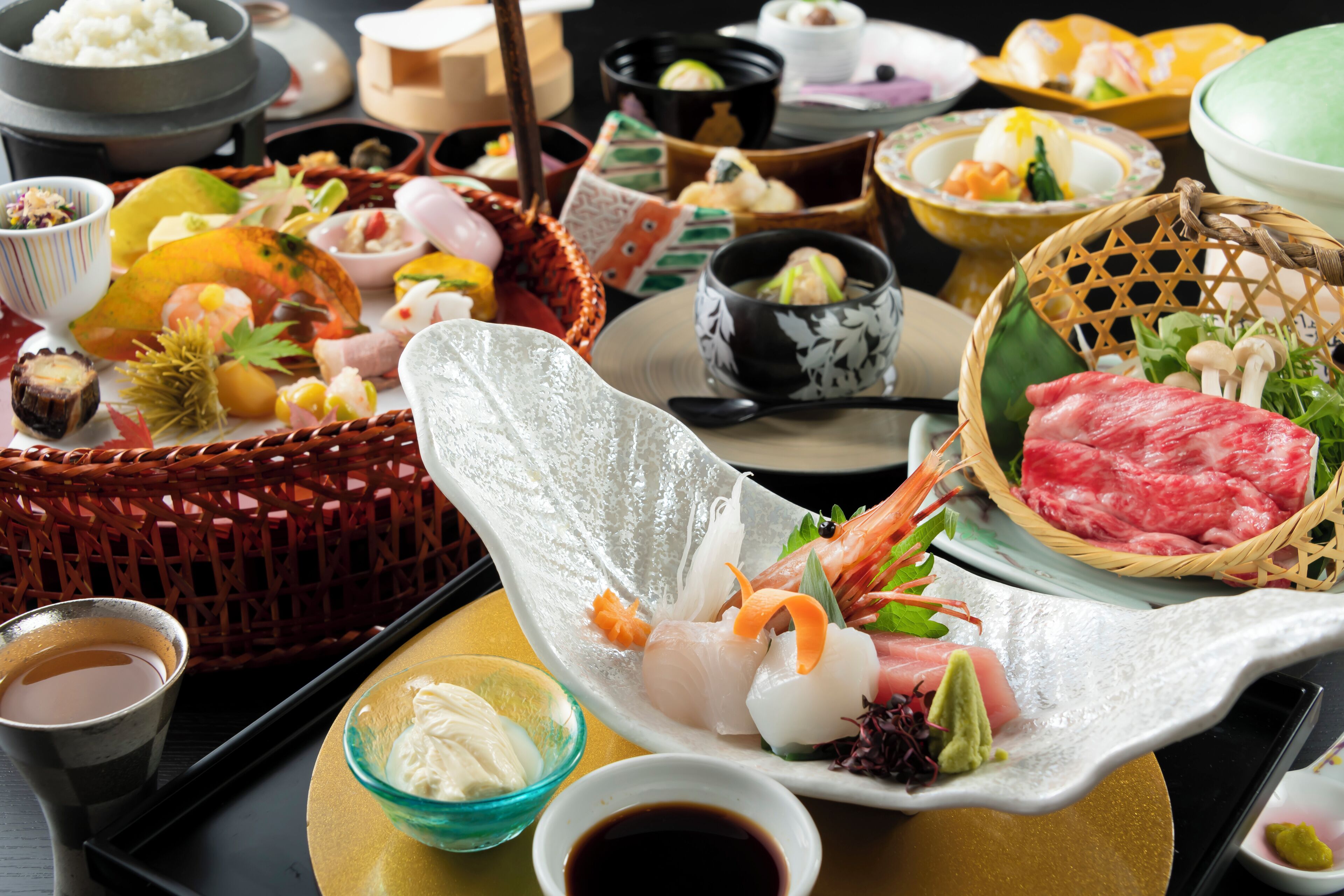 A variety of Japanese dishes including sushi, sashimi, and other delicacies arranged on a tray.