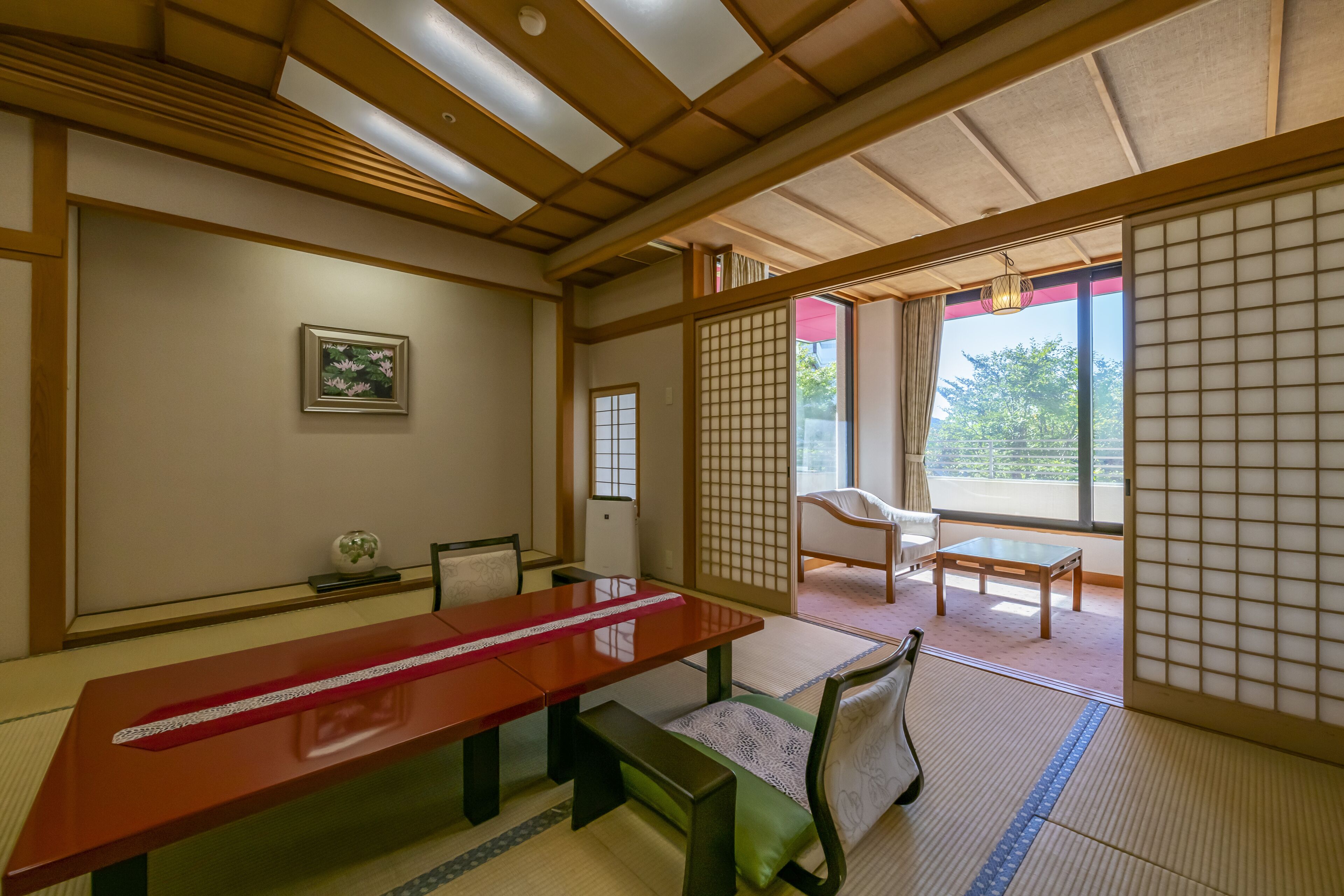 A traditional Japanese room with tatami flooring, a low wooden table, and shoji screens.