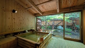A wooden spa with a hot tub, wooden walls, and a view of a garden. - KINUGAWA GRAND HOTEL YUME no TOKI (Nikko)