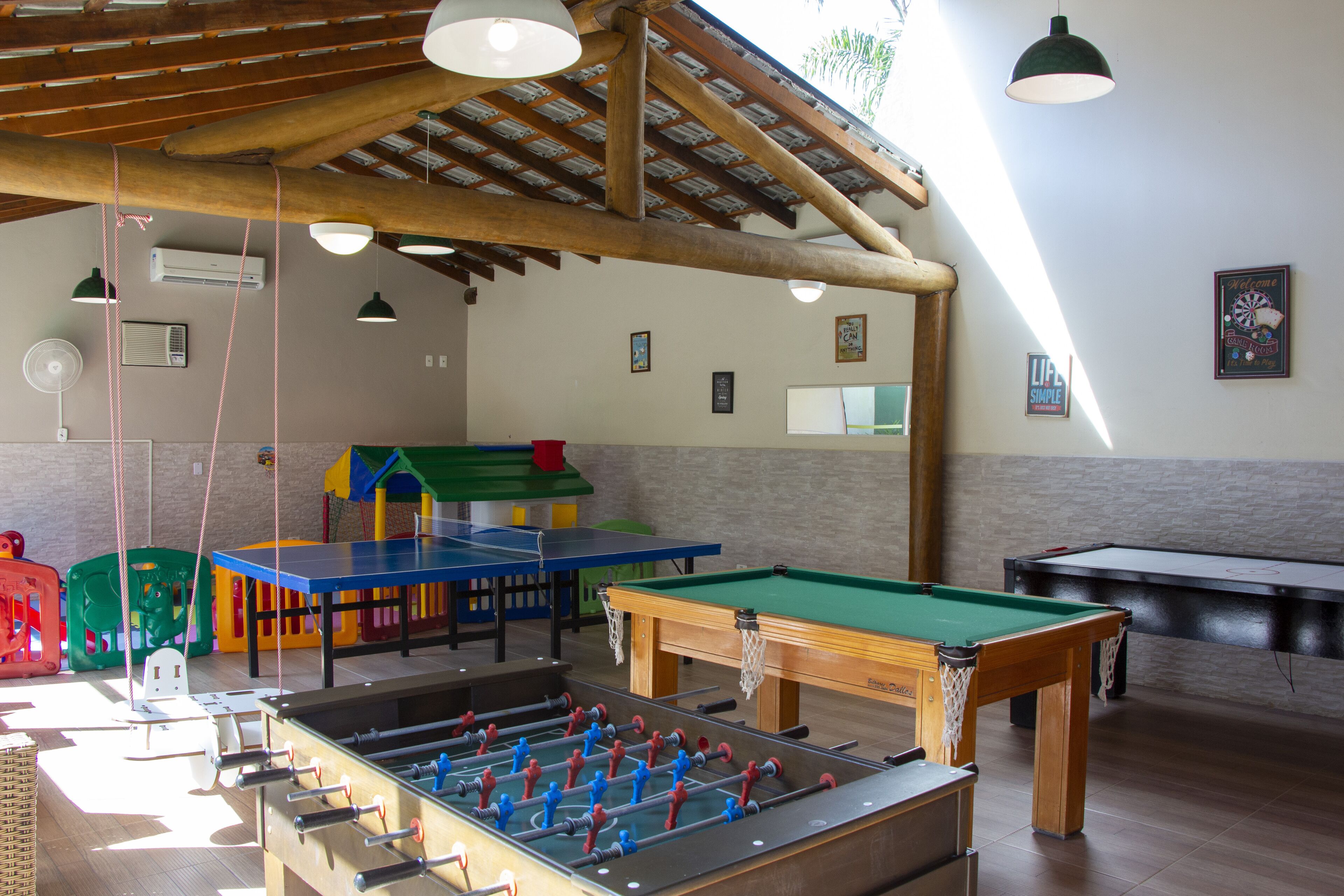 Une salle de loisirs équipée d’un baby-foot, d’une table de billard et d’une table de ping-pong.