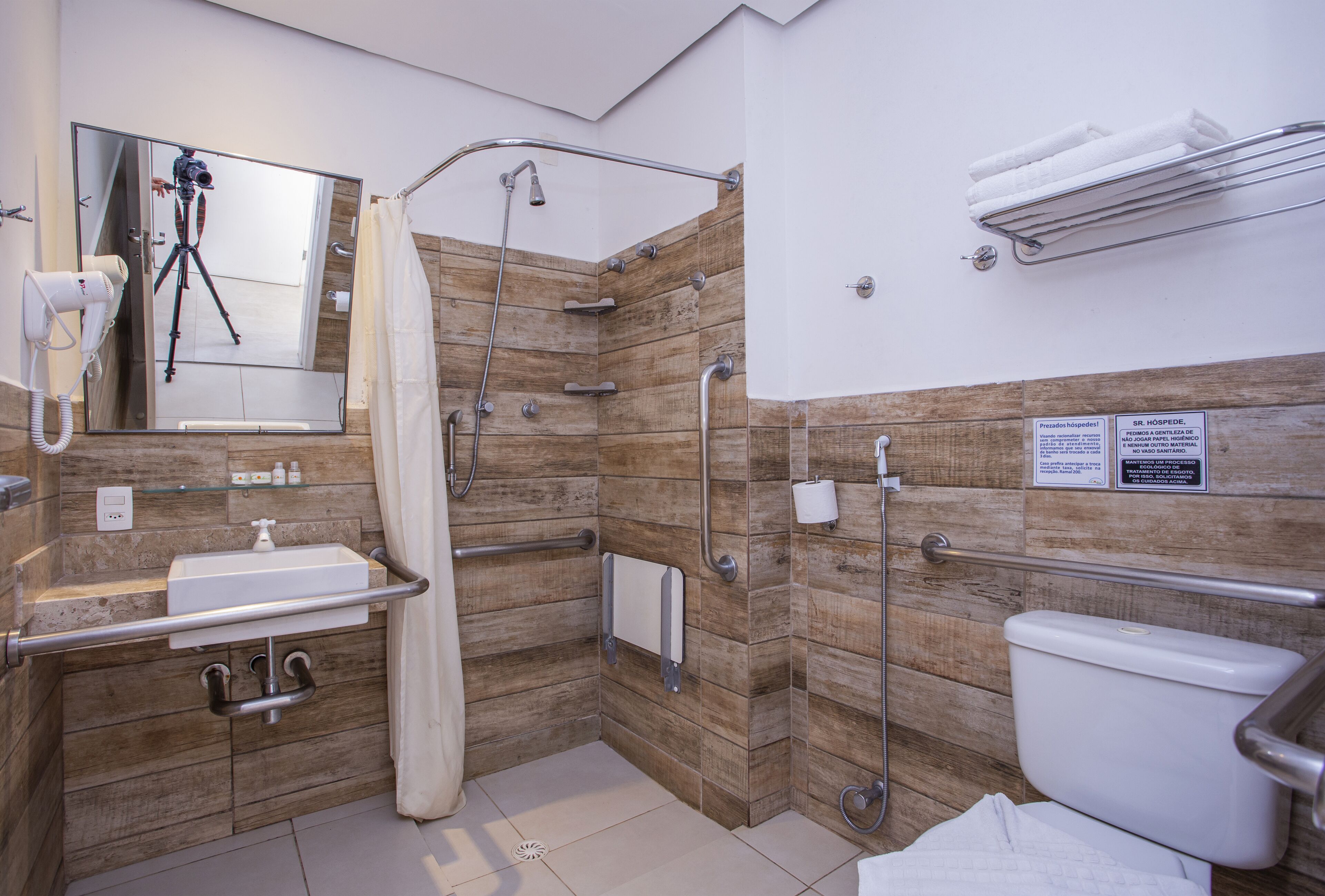 Un baño moderno con ducha, inodoro, lavabo y espejo.