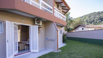 A two-story building with an open door leading to a room with a bed and a bench.
