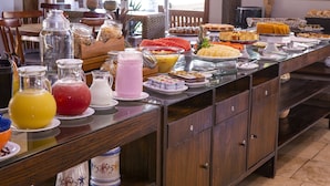 A buffet with various food items and beverages. - Ciribaí Praia Hotel (São Sebastião)