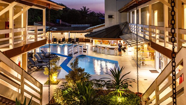 A rooftop pool area with multiple pools, bar, and seating areas. - Ciribaí Praia Hotel (São Sebastião)