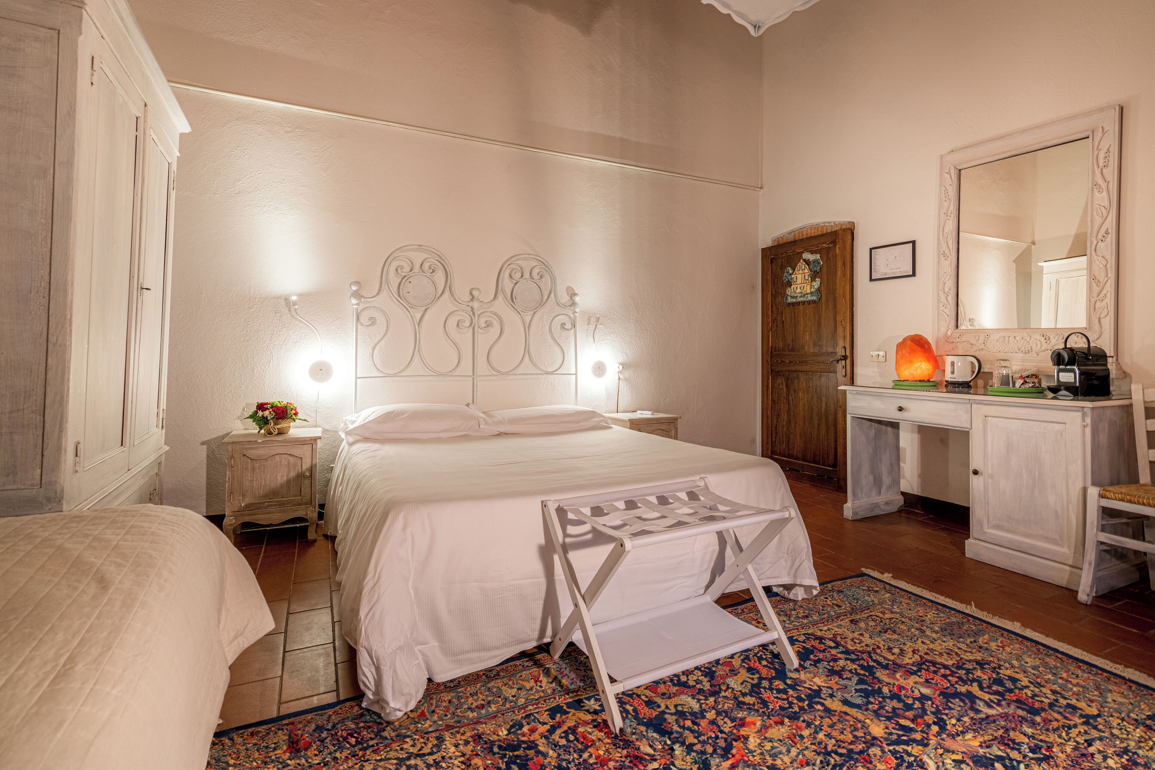 Un dormitorio con cama, mesita de noche, cómoda y espejo.