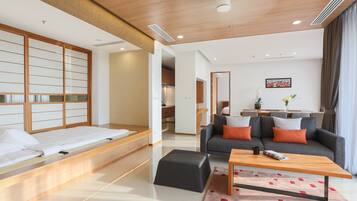 A modern hotel room with a bed, sofa, and coffee table.