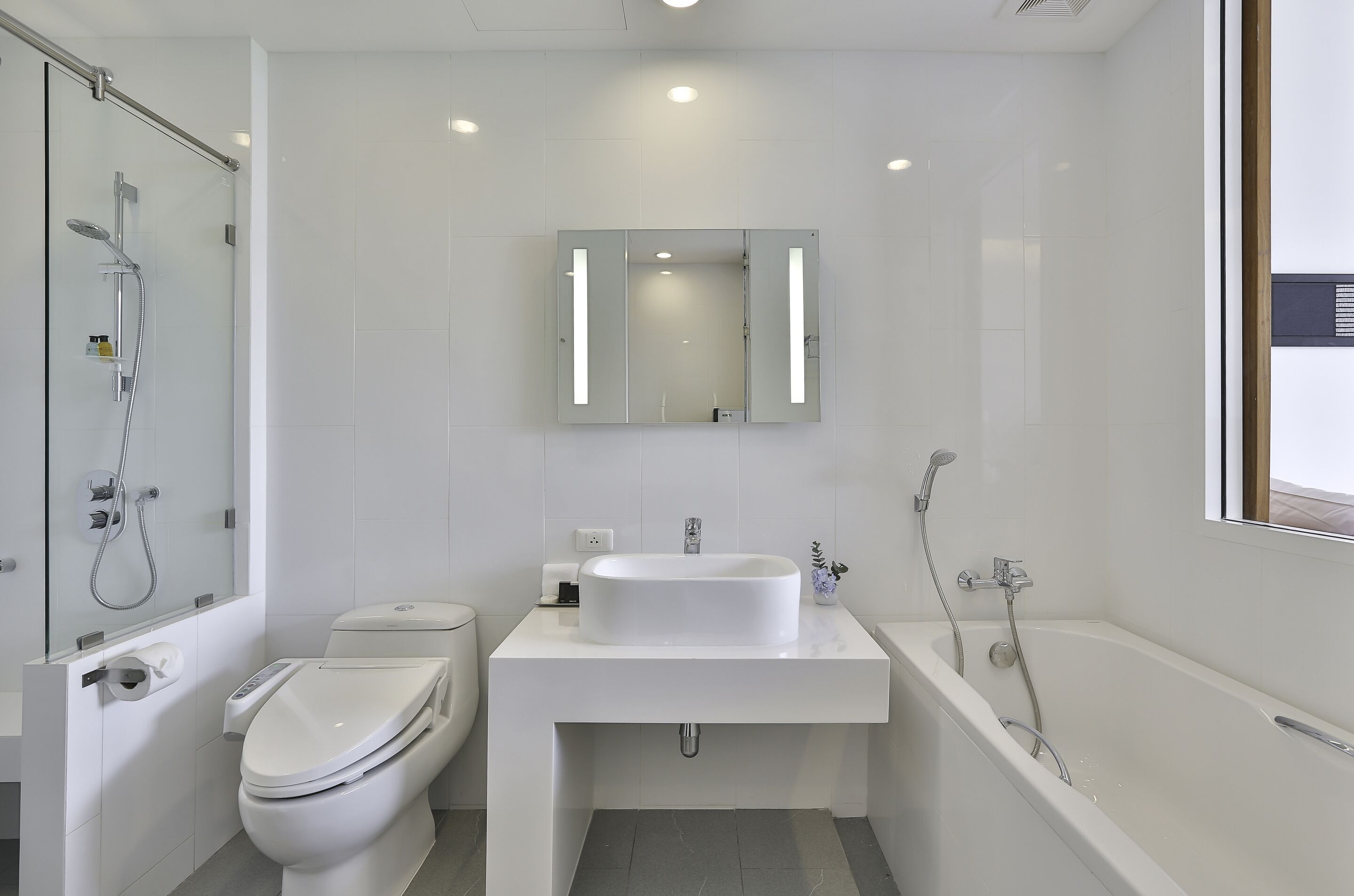 A modern bathroom with a toilet, sink, and bathtub.